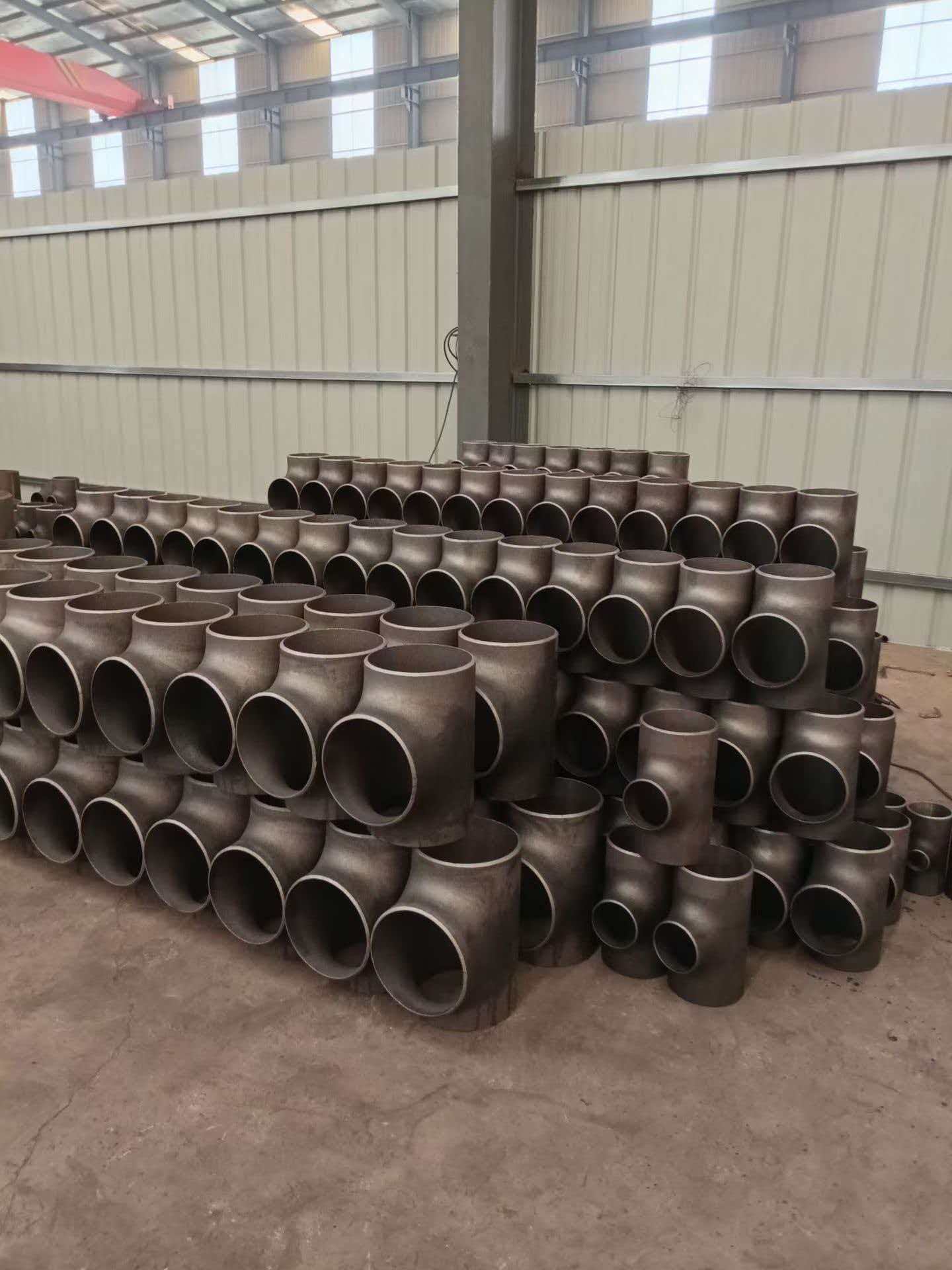 Forged tee fittings stacked in warehouse